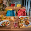 Colorful dining setup in a modern restaurant featuring diverse meals and vivid decor.